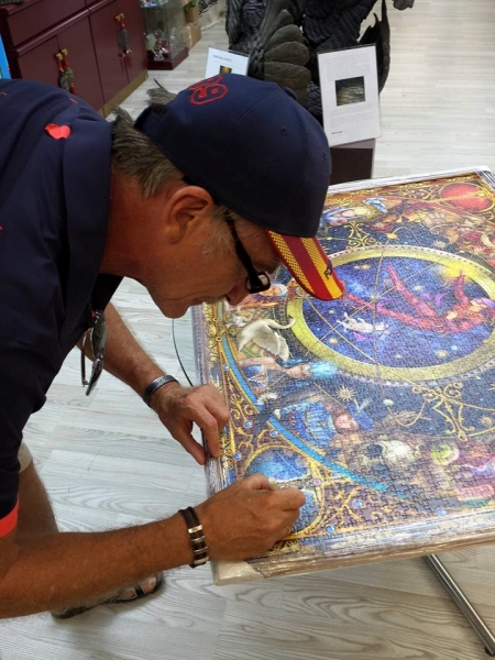 Ciro Marchetti firmando el puzzle Legacy of the Divine Tarot, ilustración suya basada en la baraja del Tarot que lleva el mismo nombre y está ilustrada por él.